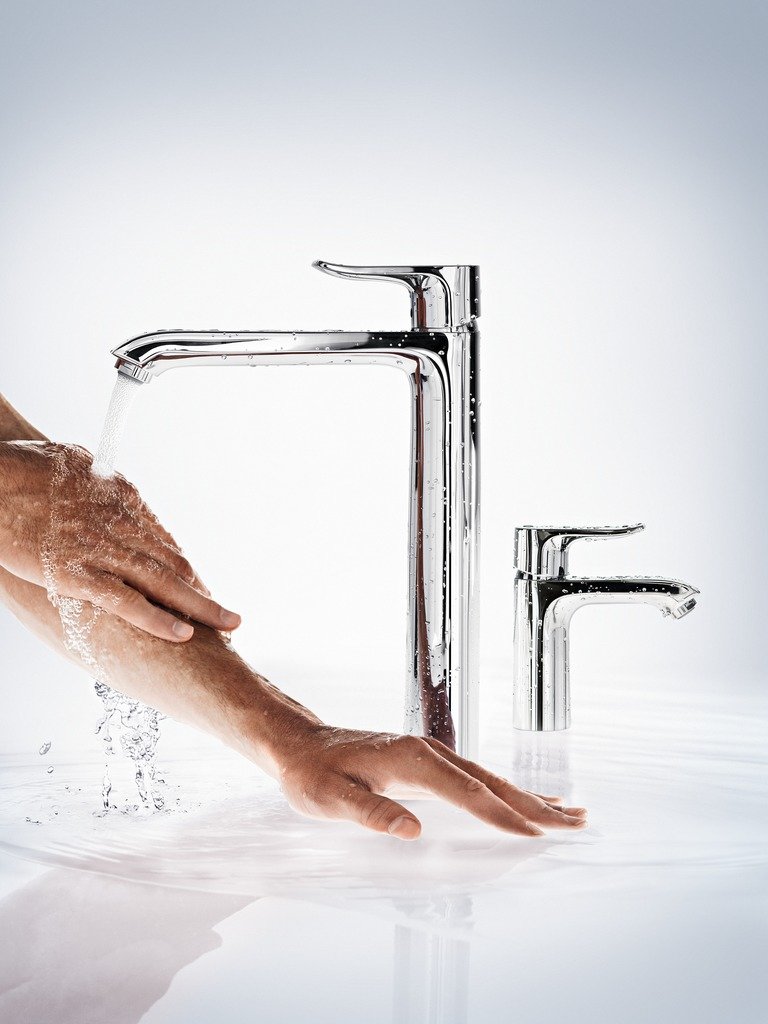 Person wäscht sich die Hände unter einem modernen Wasserhahn